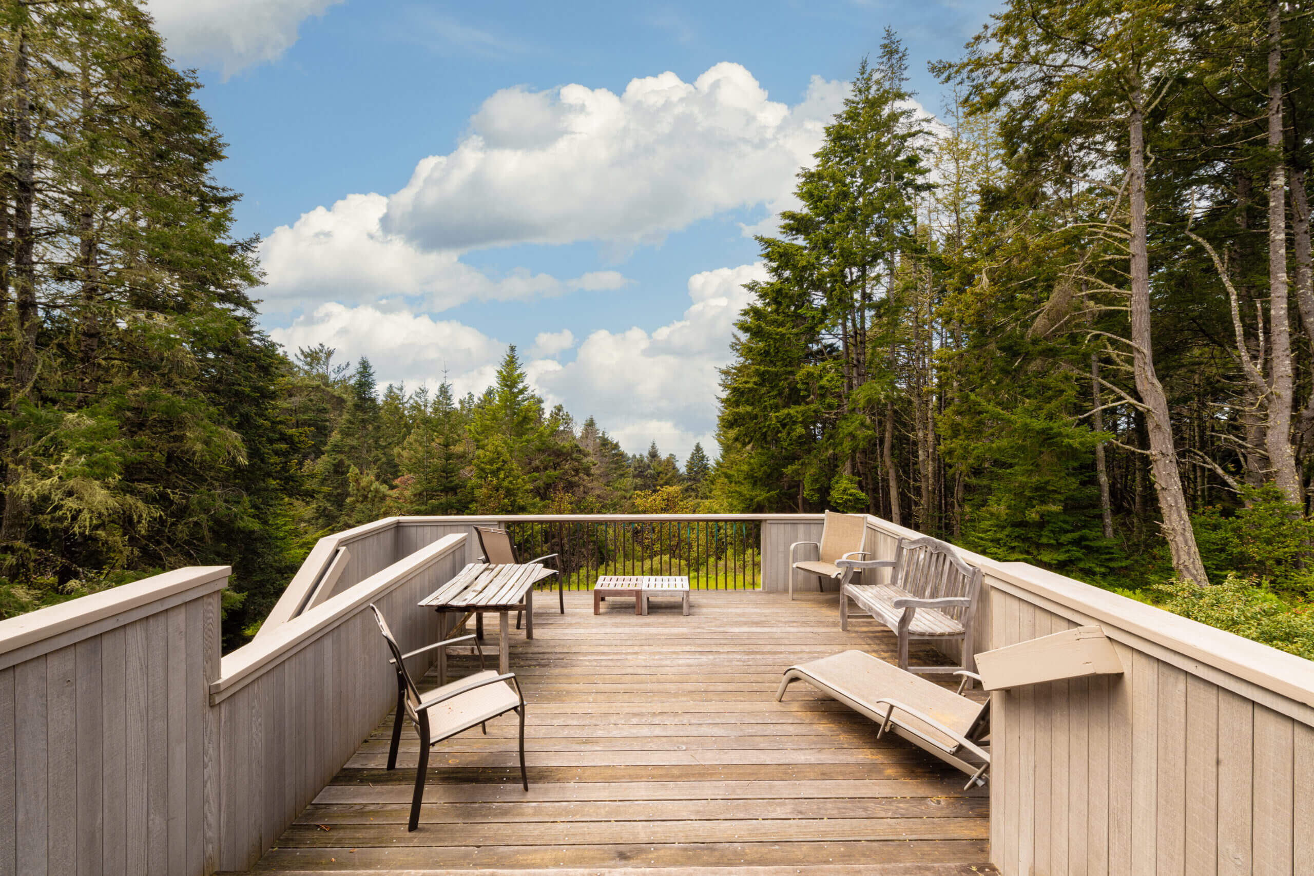 Sea Ridge deck with chairs and view of pine trees and blue sky