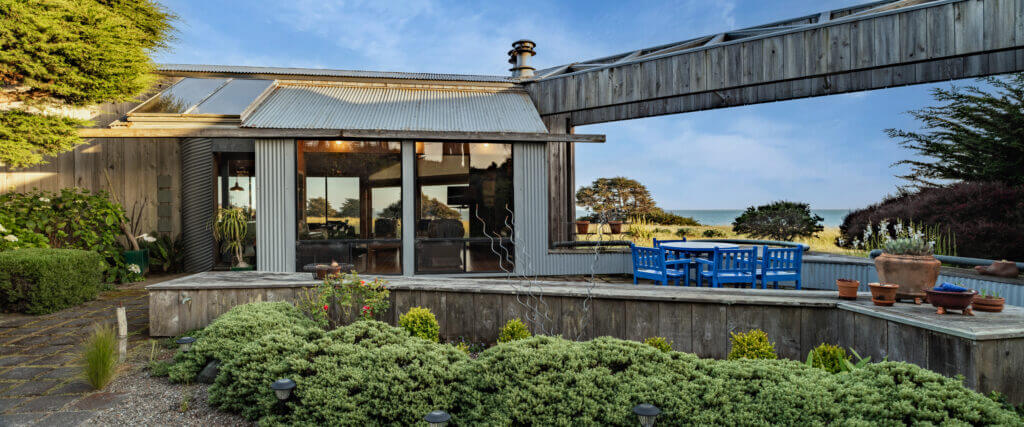 Tin Roof enclosed entry garden and outdoor dining view of ocean meadow