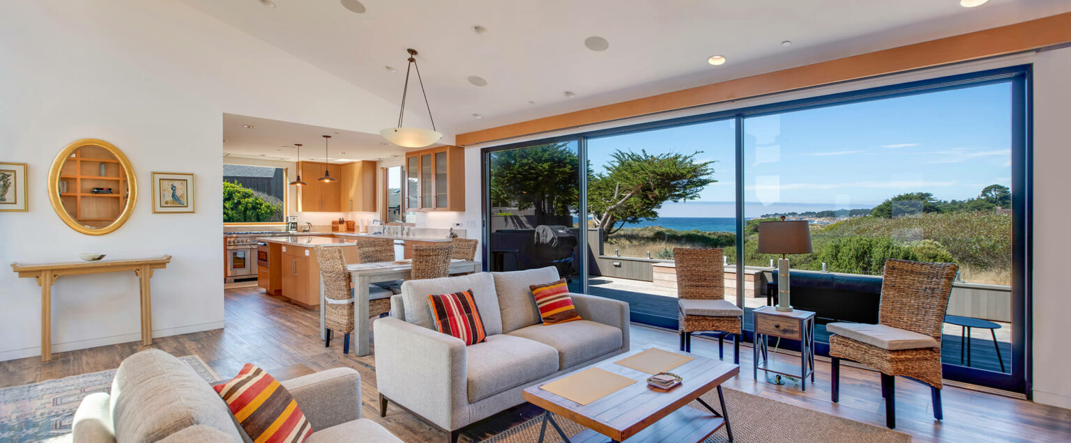 Beach Dreams living room large windows looking to ocean and view of kitchen