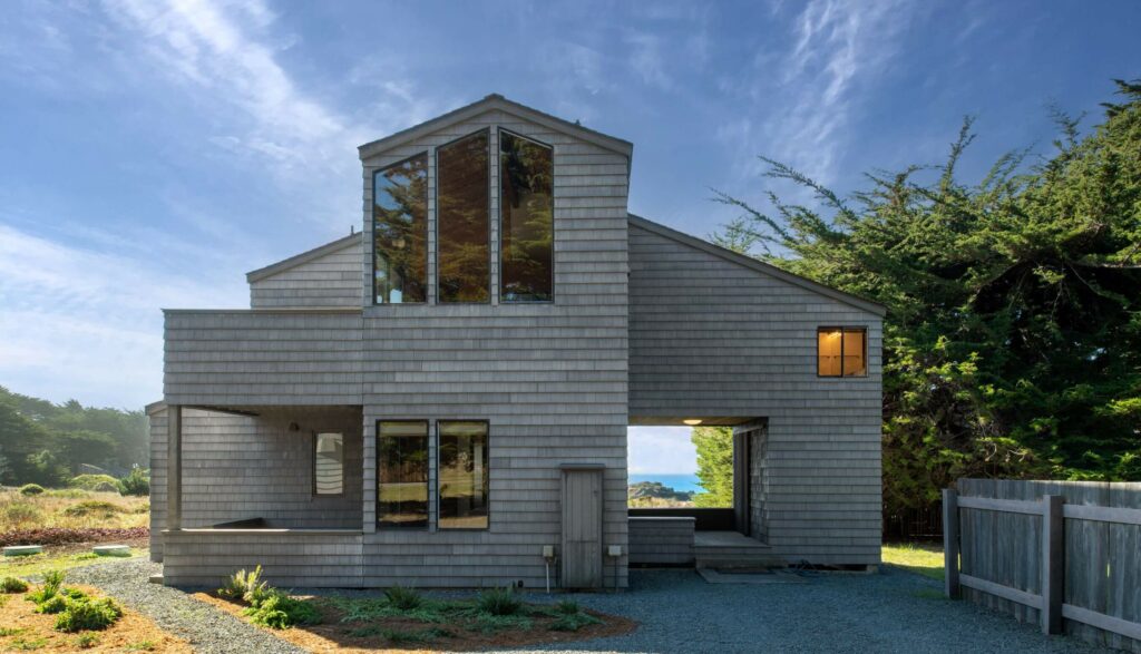 Lighthouse - gray shingled exterior against blue sky