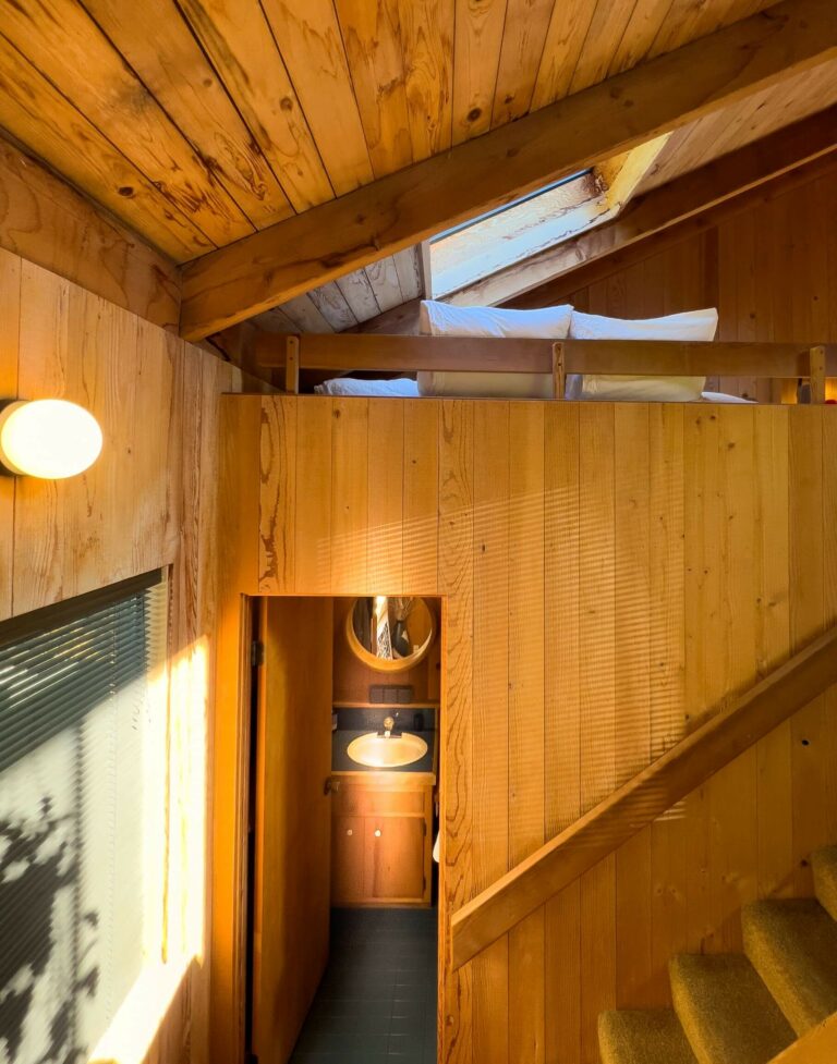 Paradiso - bright wood paneled staircase with view of bathroom and loft bed