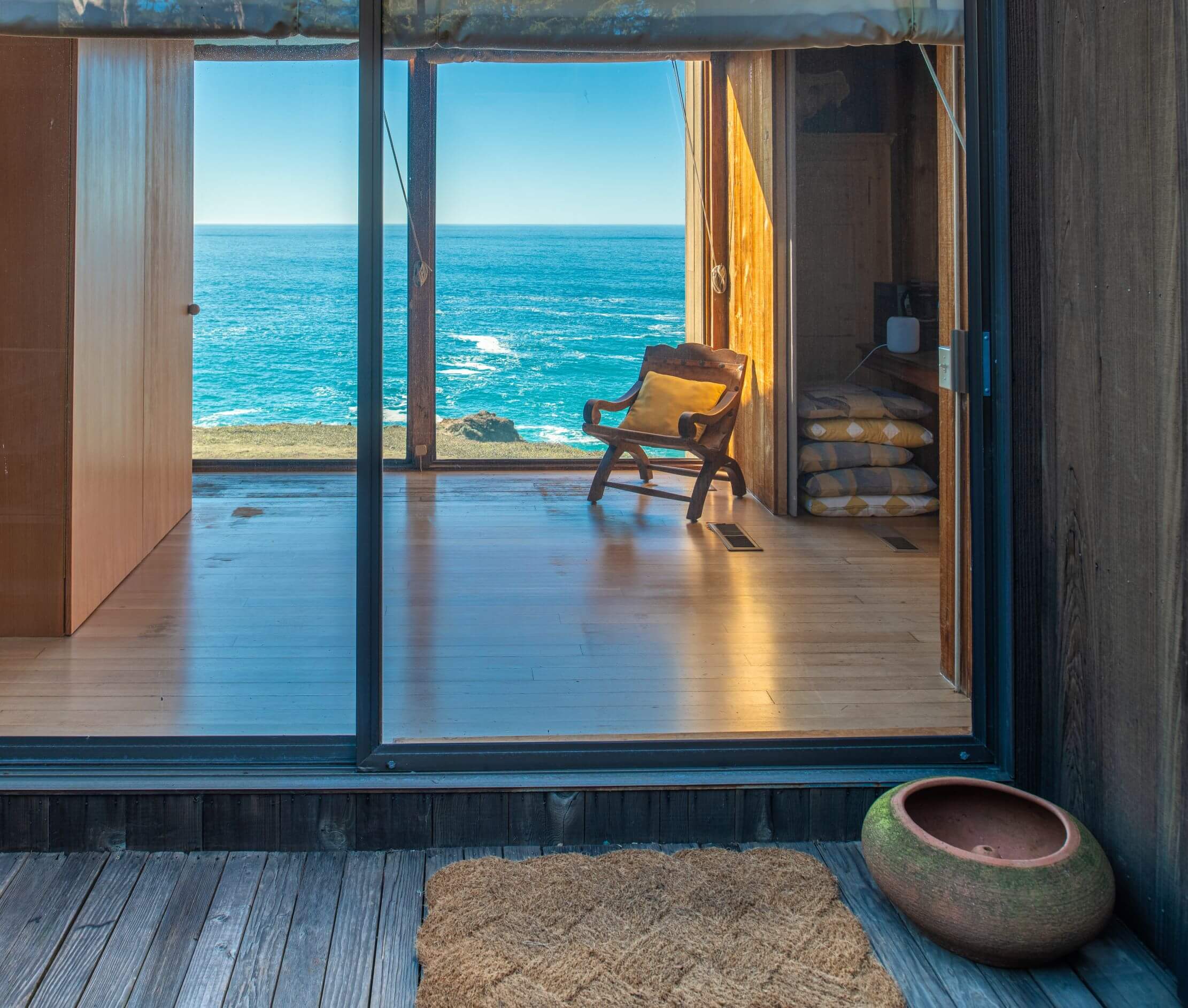 Moore Condo #9 - outdoor exterior entryway looking into large window and view of ocean.