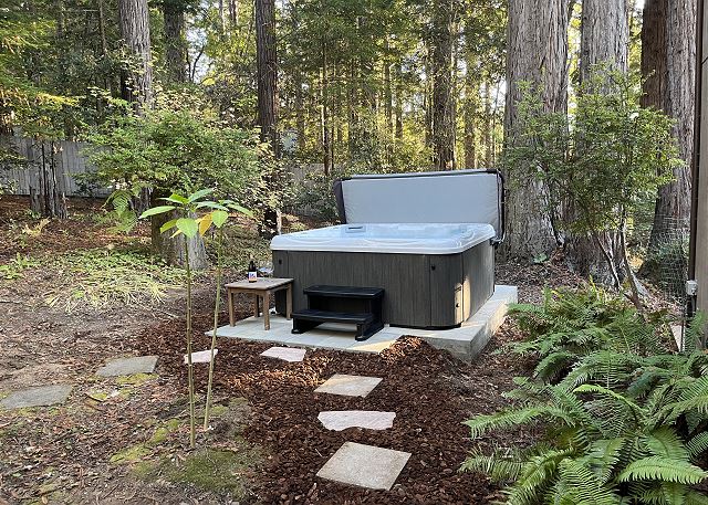 Sea Pony - rear exterior view of hot tub with forest surrounding.