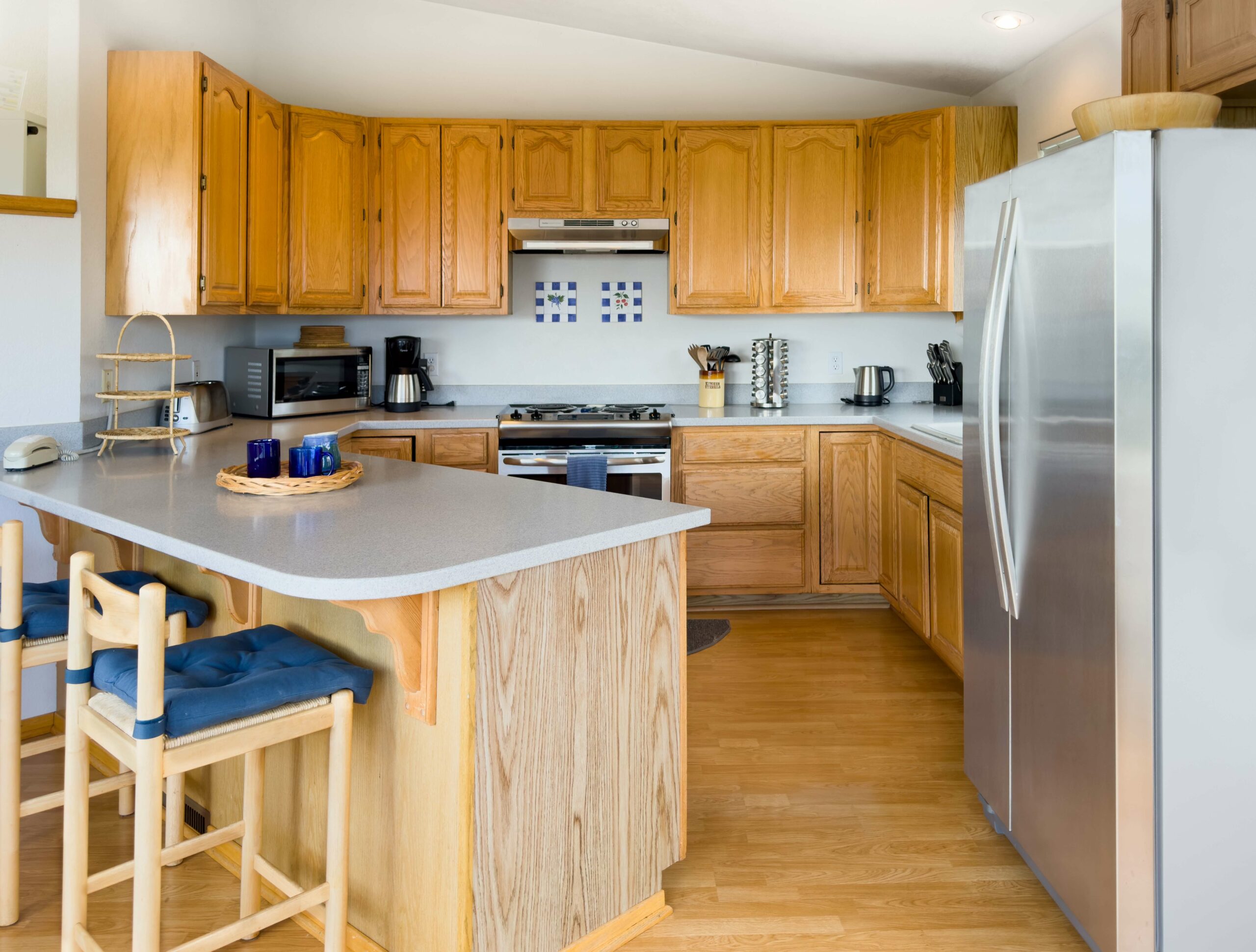 Mare Vista: kitchen with wood cabinets, floors and breakfast bar.