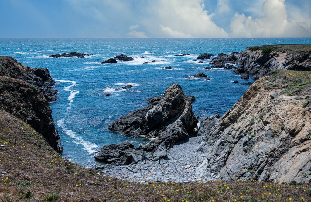 Cove Overlook - blue sky, seaside rocks with blue water crashing.