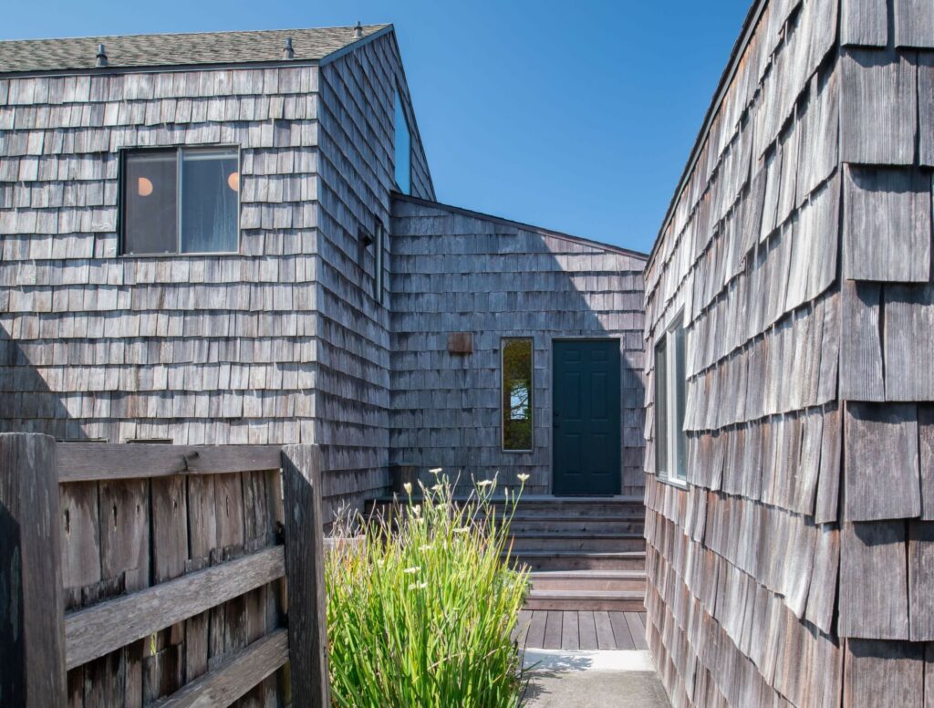 Sea Meadow: outdoor view of shingled home entrance against blue sky