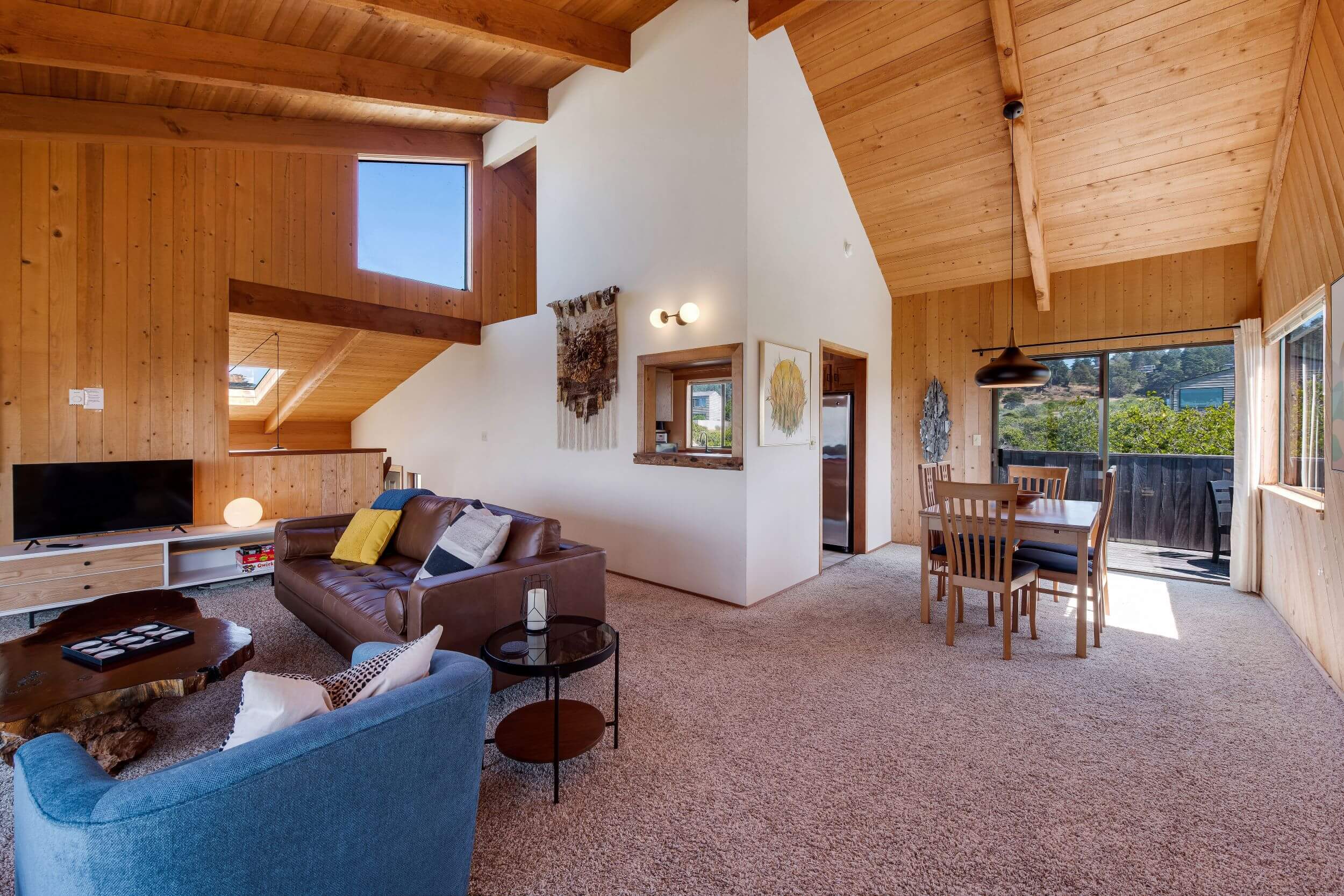 Sea Meadow: large open living room with wood ceilings with view of dining table.