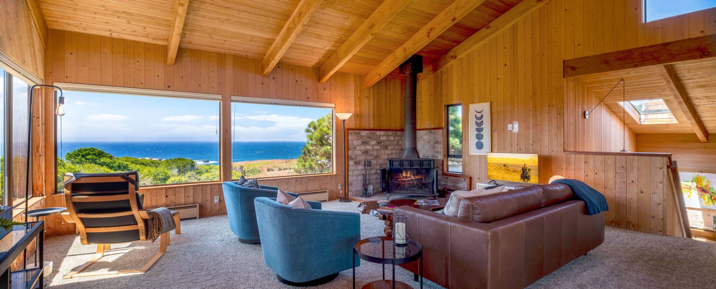 Sea Meadow: large view of living room, wood walls and ceiling, large windows with view of ocean.