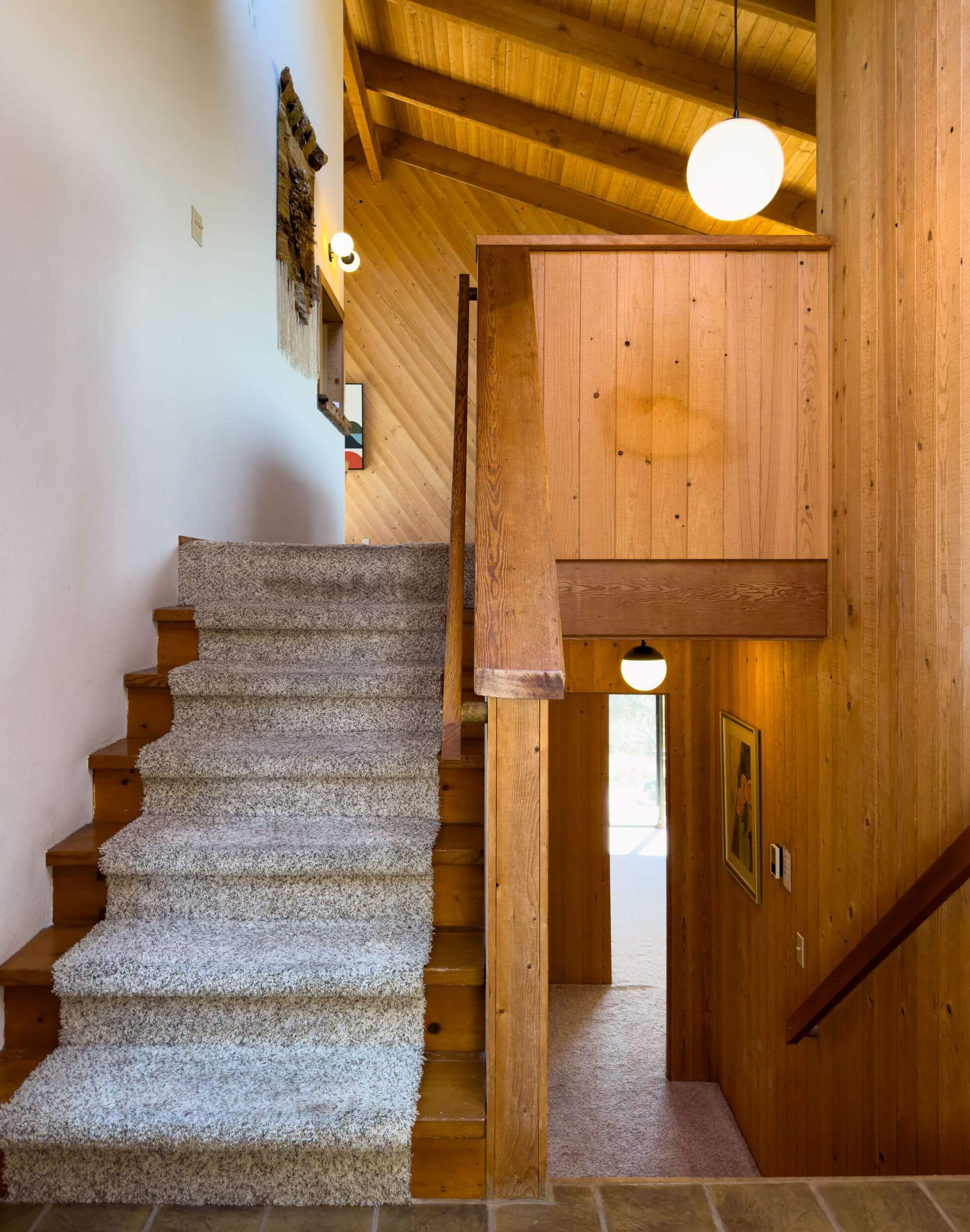 Sea Meadow: view of carpeted stairway to upper and lower floors, wood walls and ceilings.