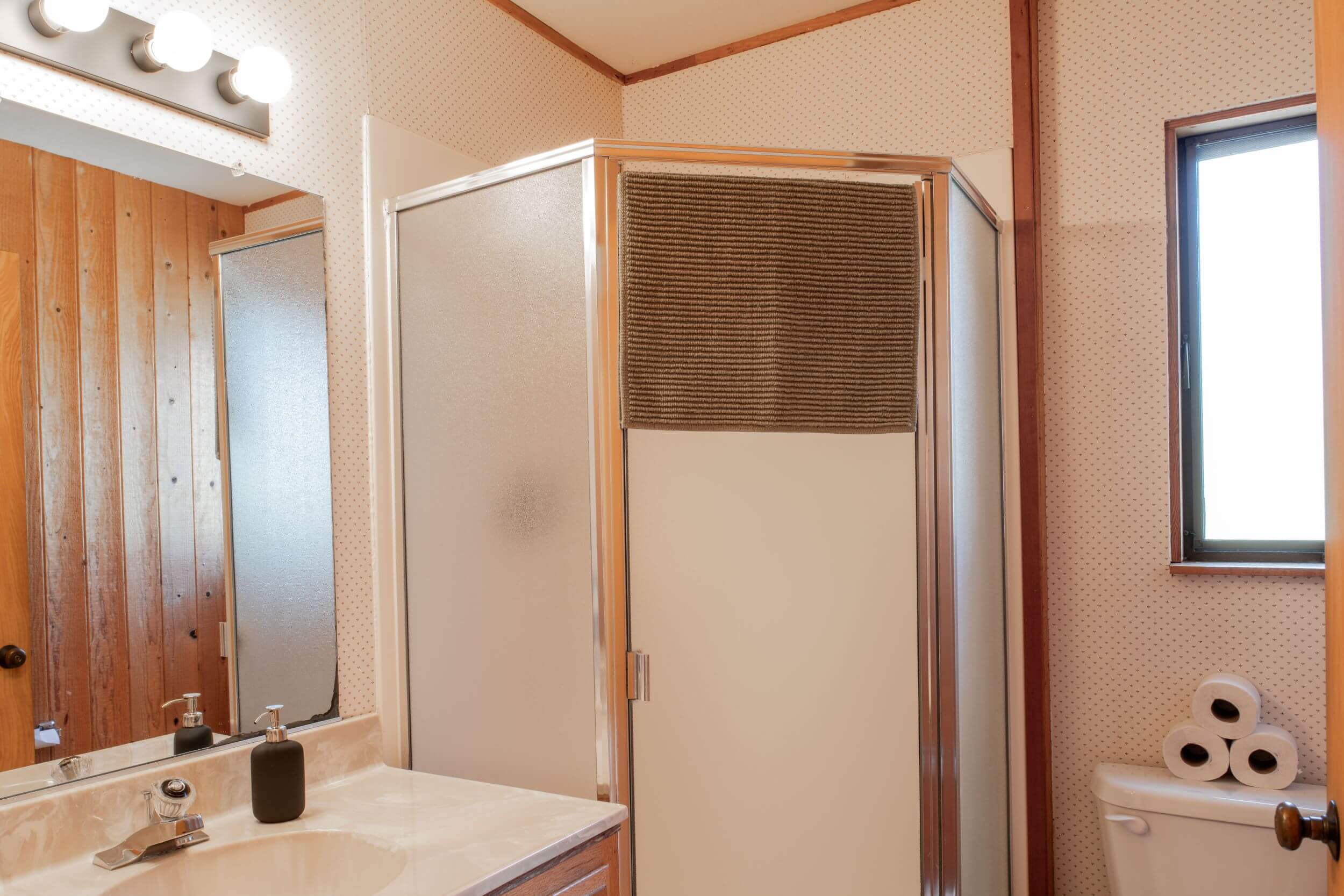 Sea Meadow: bright 1st bathroom with corner walk in shower and vanity.