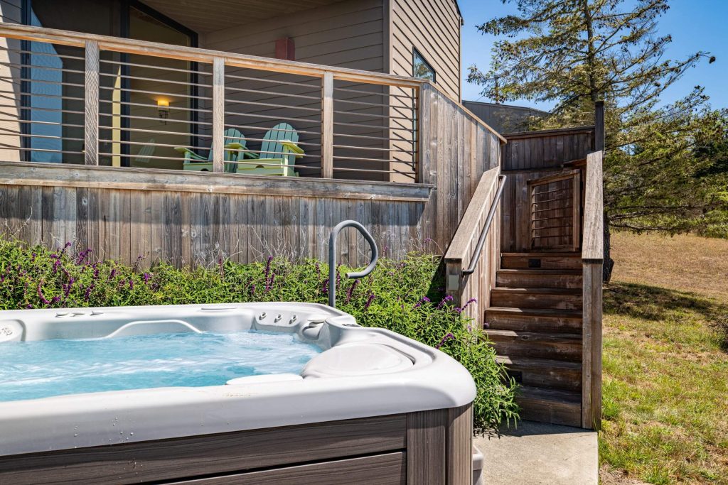 Cornwall West - exterior hot tub and stairs up to deck of home.