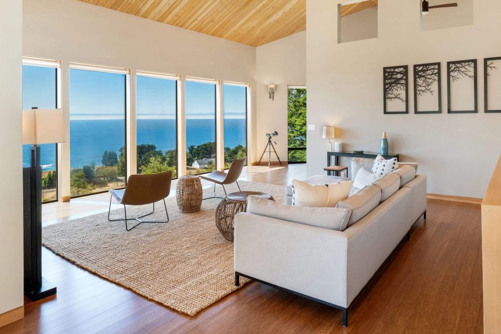 Cornwall West - bright living area with large wall of windows looking to the ocean