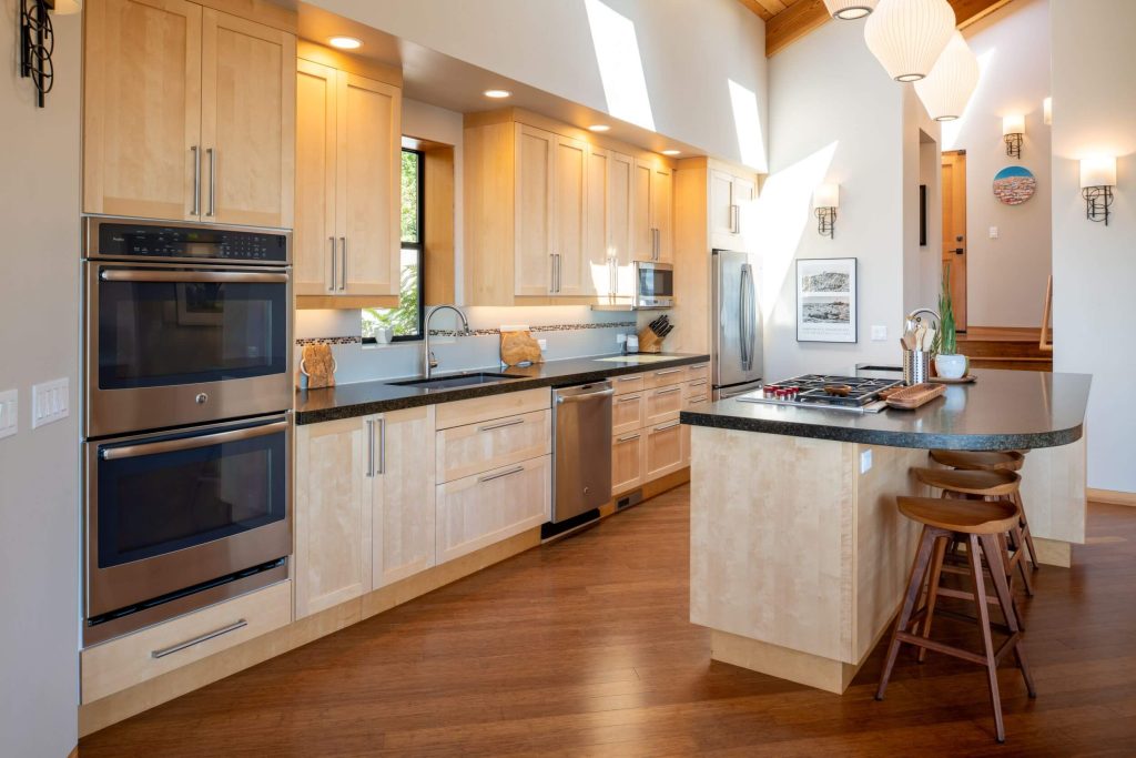 Cornwall West - large open and bright kitchen with wood floors and cabinets and breakfast counter.