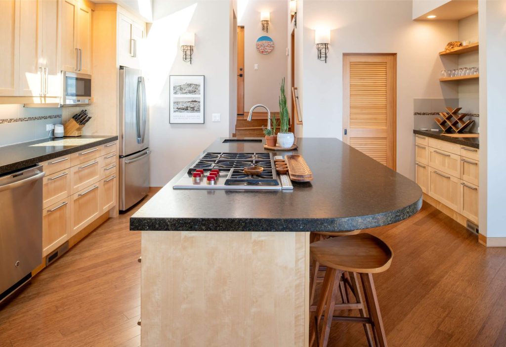 Cornwall West - large open and bright kitchen with wood floors and cabinets and breakfast counter.