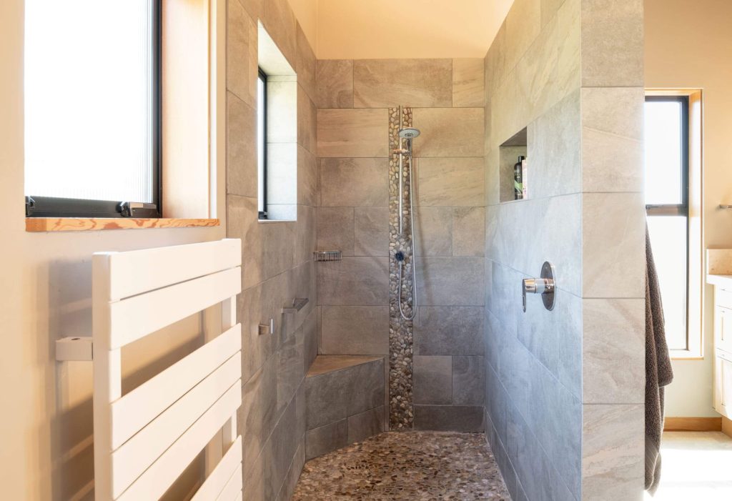 Cornwall West - bright master bathroom with large walk-in marble and pebbled shower.