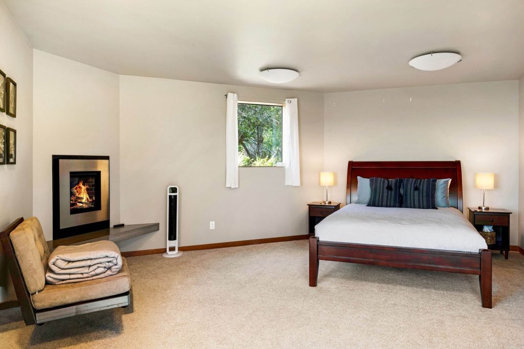 Cornwall West - bright carpeted 1st guest bedroom with small fireplace in wall.