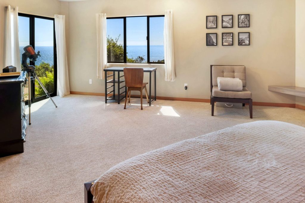 Cornwall West - bright carpeted 1st guest bedroom with deck doors looking to ocean.